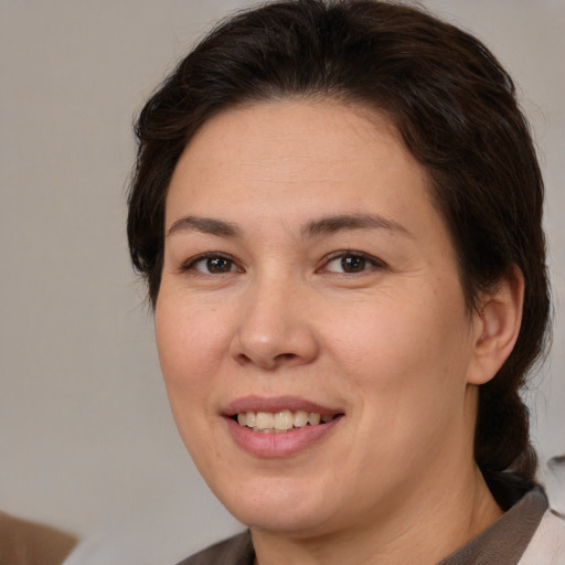 Joyful white adult female with medium  brown hair and brown eyes