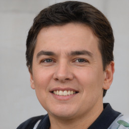 Joyful white young-adult male with short  brown hair and grey eyes