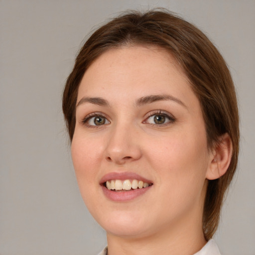 Joyful white young-adult female with medium  brown hair and green eyes