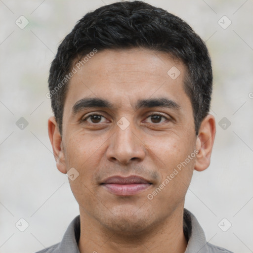 Joyful latino young-adult male with short  black hair and brown eyes