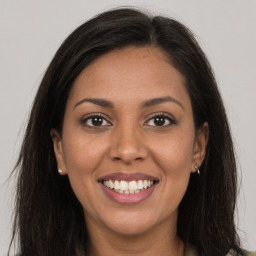 Joyful latino young-adult female with long  brown hair and brown eyes