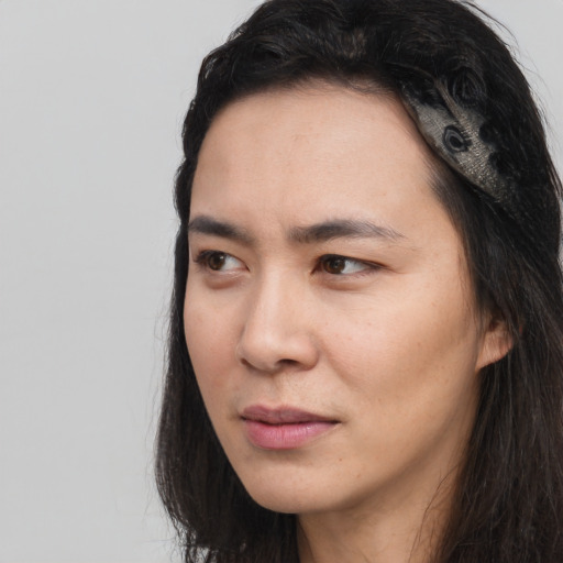 Joyful asian young-adult female with long  black hair and brown eyes