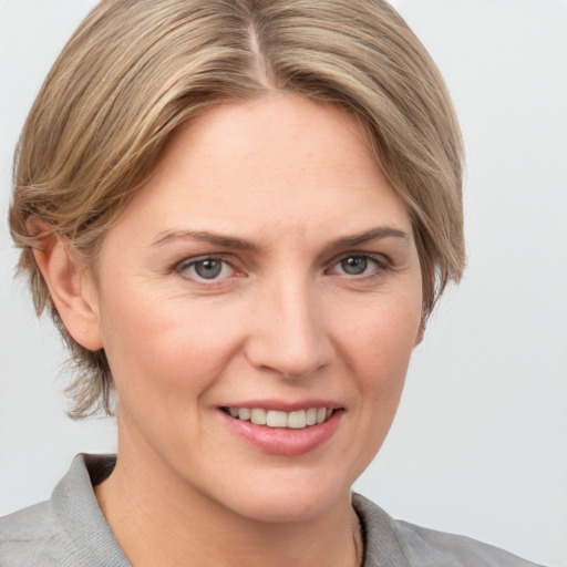 Joyful white adult female with medium  brown hair and grey eyes