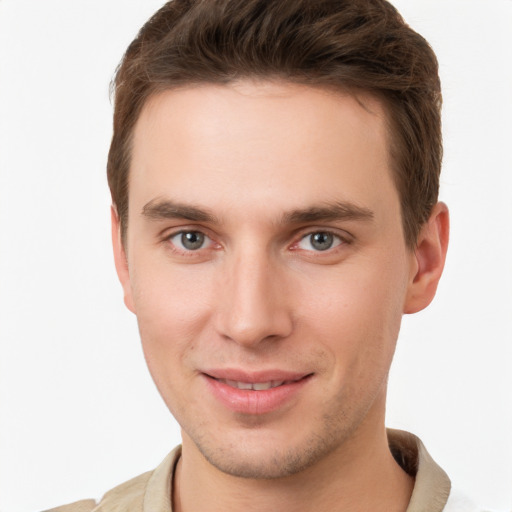 Joyful white young-adult male with short  brown hair and grey eyes