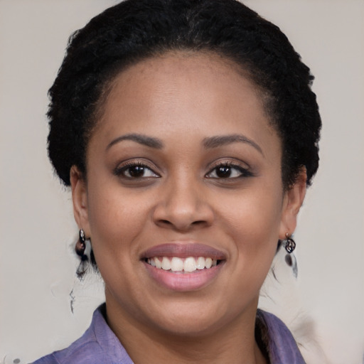 Joyful black young-adult female with long  black hair and brown eyes
