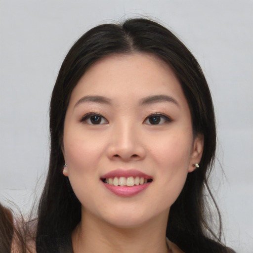 Joyful asian young-adult female with long  black hair and brown eyes
