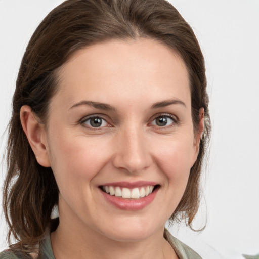 Joyful white young-adult female with medium  brown hair and grey eyes