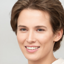 Joyful white young-adult female with medium  brown hair and grey eyes