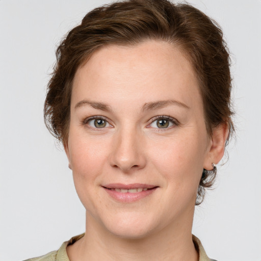 Joyful white young-adult female with short  brown hair and grey eyes