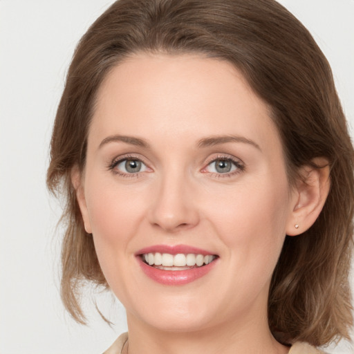 Joyful white young-adult female with medium  brown hair and green eyes