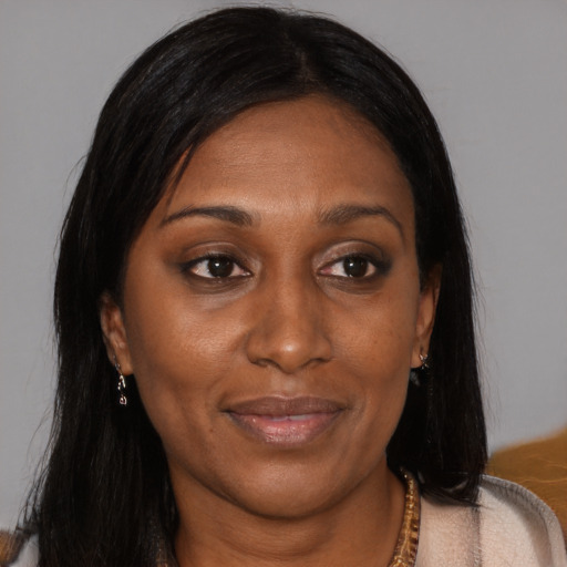Joyful black adult female with long  brown hair and brown eyes