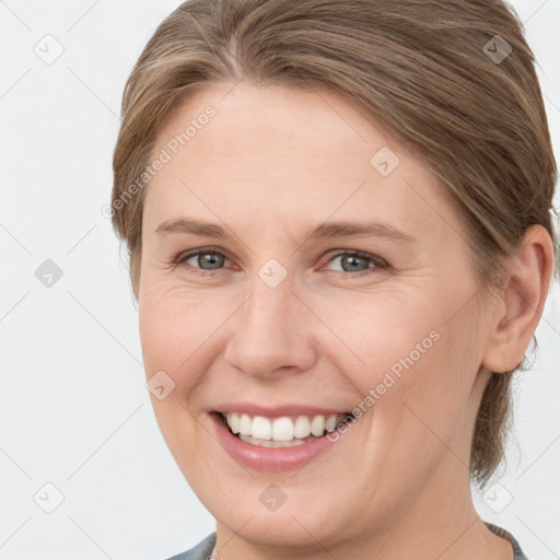 Joyful white young-adult female with medium  brown hair and grey eyes