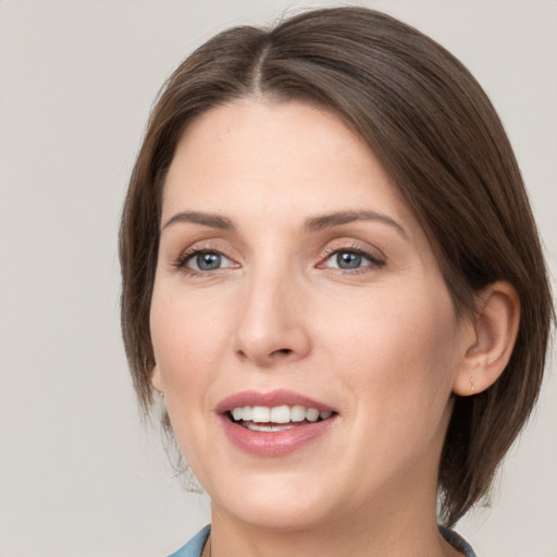 Joyful white young-adult female with medium  brown hair and grey eyes