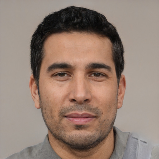 Joyful white young-adult male with short  black hair and brown eyes