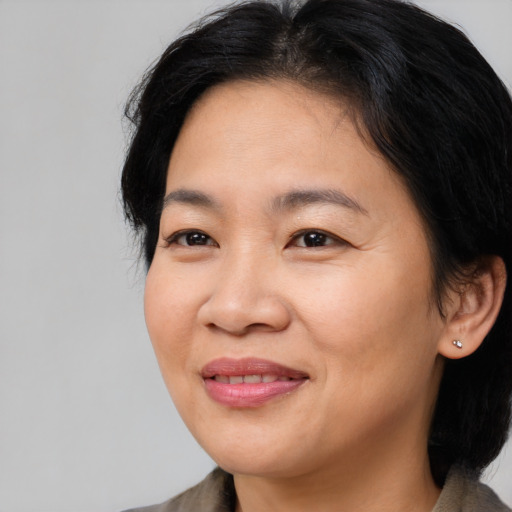 Joyful asian adult female with medium  brown hair and brown eyes