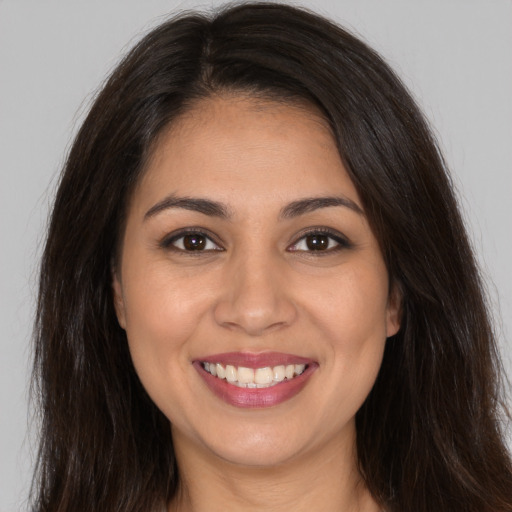 Joyful white young-adult female with long  brown hair and brown eyes