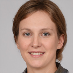 Joyful white adult female with medium  brown hair and grey eyes