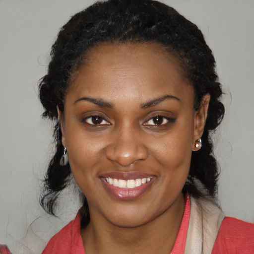 Joyful black young-adult female with long  black hair and brown eyes