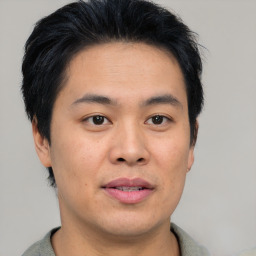 Joyful asian young-adult male with short  brown hair and brown eyes