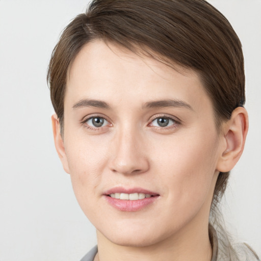 Joyful white young-adult female with short  brown hair and grey eyes