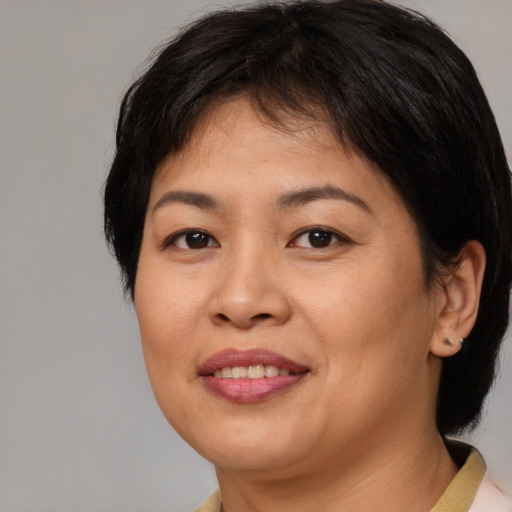 Joyful asian adult female with medium  brown hair and brown eyes