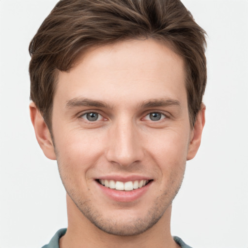 Joyful white young-adult male with short  brown hair and grey eyes