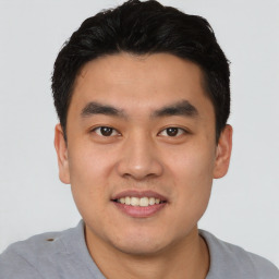 Joyful asian young-adult male with short  black hair and brown eyes