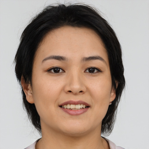 Joyful asian young-adult female with medium  brown hair and brown eyes