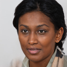 Joyful black young-adult female with long  brown hair and brown eyes