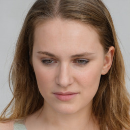 Joyful white young-adult female with long  brown hair and blue eyes