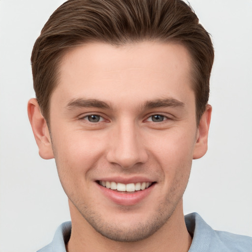 Joyful white young-adult male with short  brown hair and grey eyes