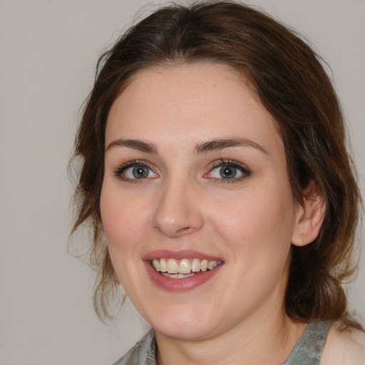 Joyful white young-adult female with medium  brown hair and blue eyes