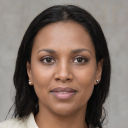 Joyful black young-adult female with long  brown hair and brown eyes