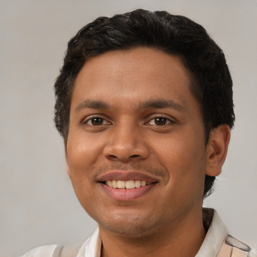 Joyful latino young-adult male with short  brown hair and brown eyes