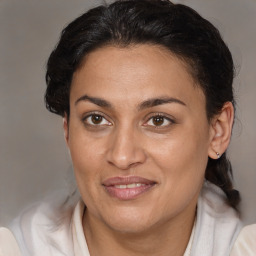 Joyful latino adult female with medium  brown hair and brown eyes