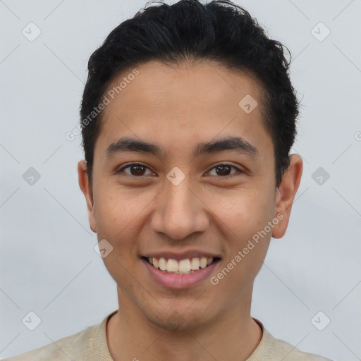 Joyful latino young-adult male with short  brown hair and brown eyes