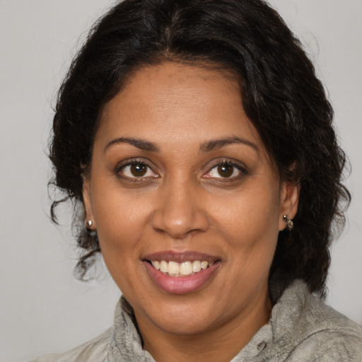 Joyful black adult female with medium  brown hair and brown eyes