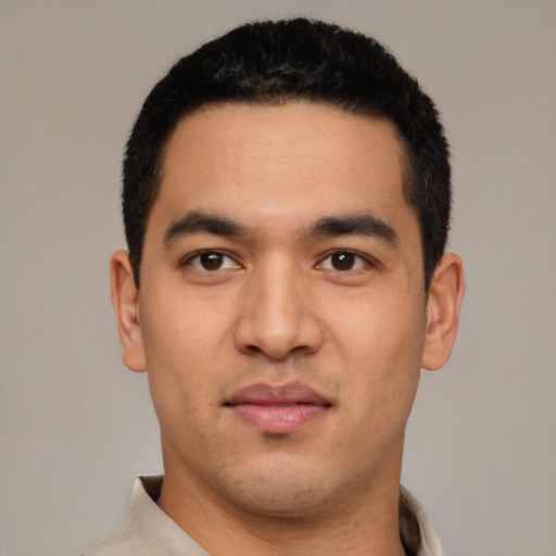 Joyful latino young-adult male with short  black hair and brown eyes