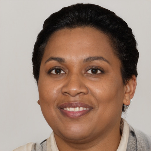 Joyful black adult female with short  black hair and brown eyes