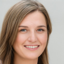 Joyful white young-adult female with long  brown hair and blue eyes