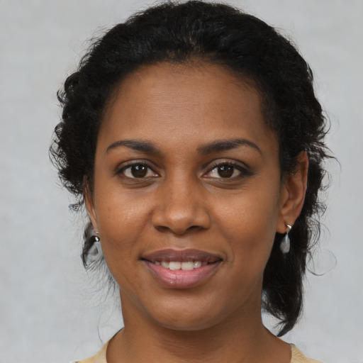Joyful black young-adult female with medium  brown hair and brown eyes