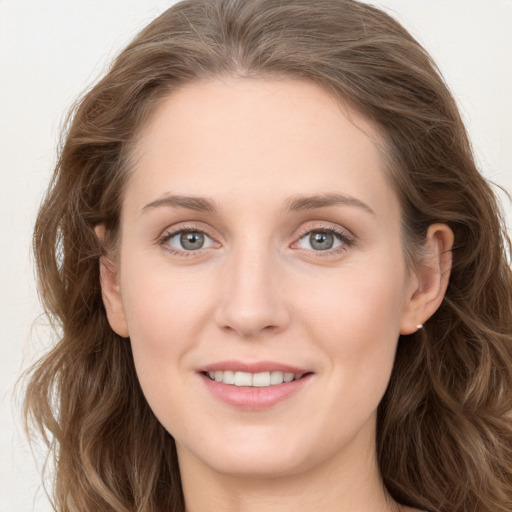 Joyful white young-adult female with long  brown hair and blue eyes