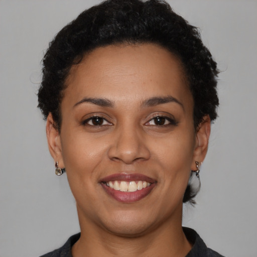 Joyful black young-adult female with short  brown hair and brown eyes
