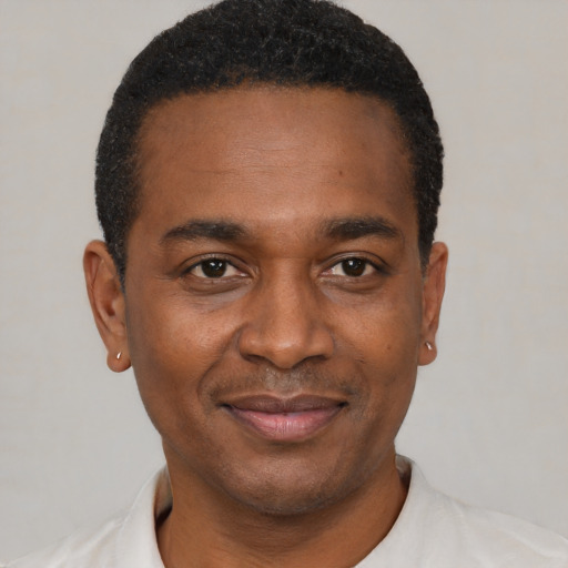 Joyful black young-adult male with short  black hair and brown eyes
