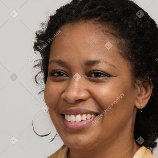 Joyful black young-adult female with long  brown hair and brown eyes