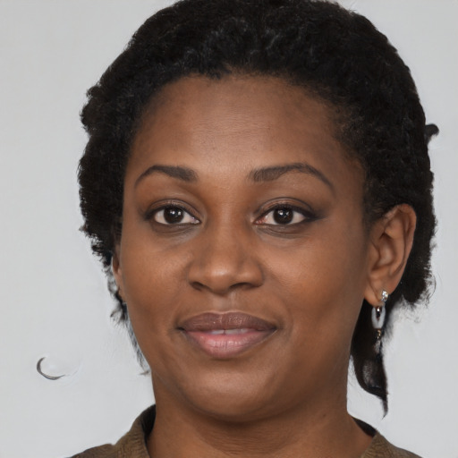 Joyful black adult female with medium  brown hair and brown eyes