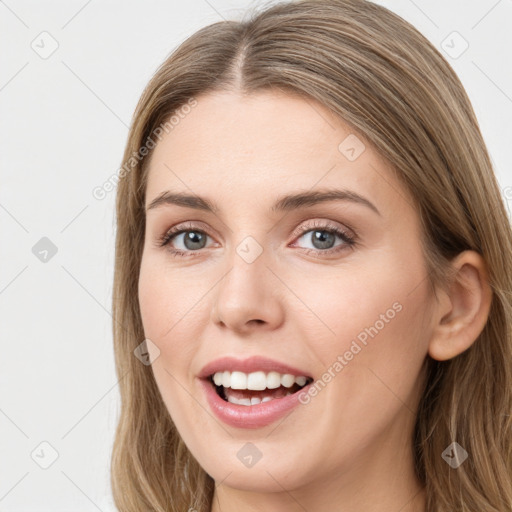 Joyful white young-adult female with long  brown hair and grey eyes