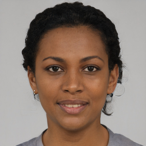 Joyful black young-adult female with short  black hair and brown eyes