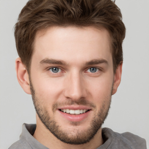 Joyful white young-adult male with short  brown hair and grey eyes