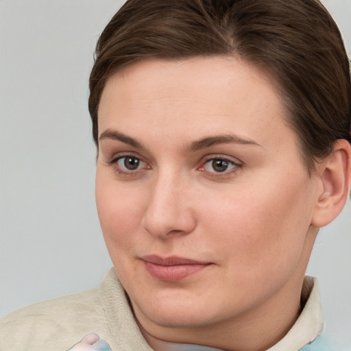 Joyful white young-adult female with short  brown hair and grey eyes